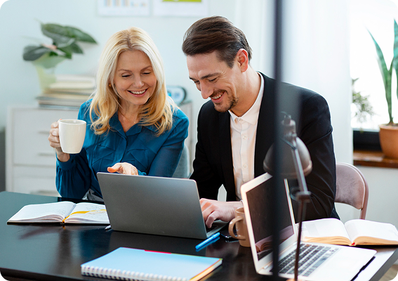 Femme et Homme souriants devant ordinateur